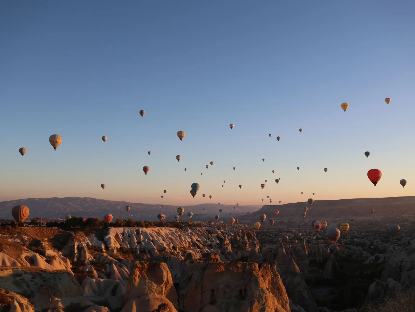 Gün doğumunda Kapadokya vadileri üzerinde sıcak hava balonları